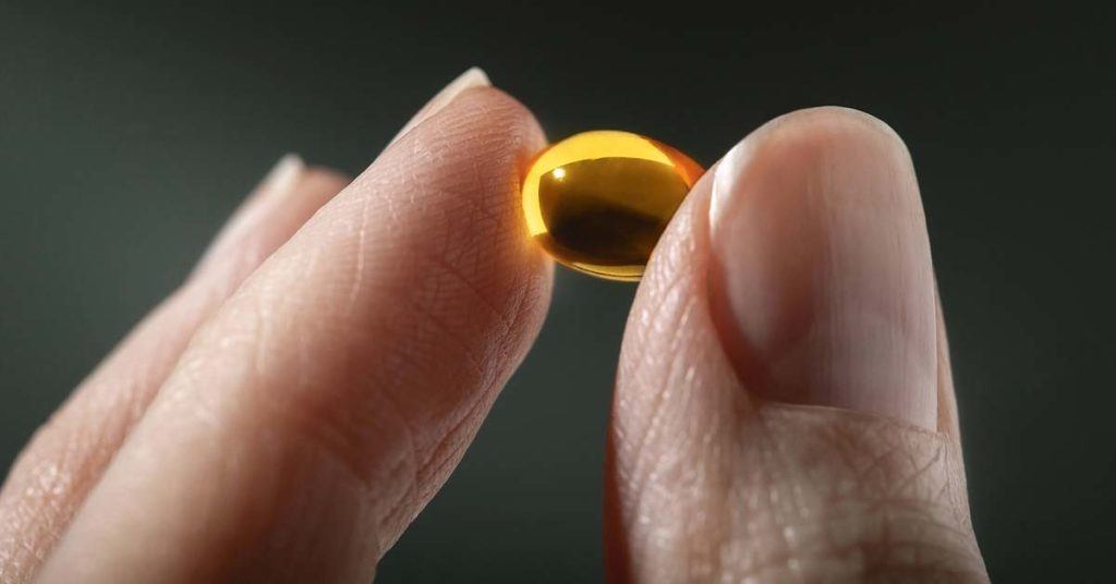 person holding vitamin pill as an example of a supplement