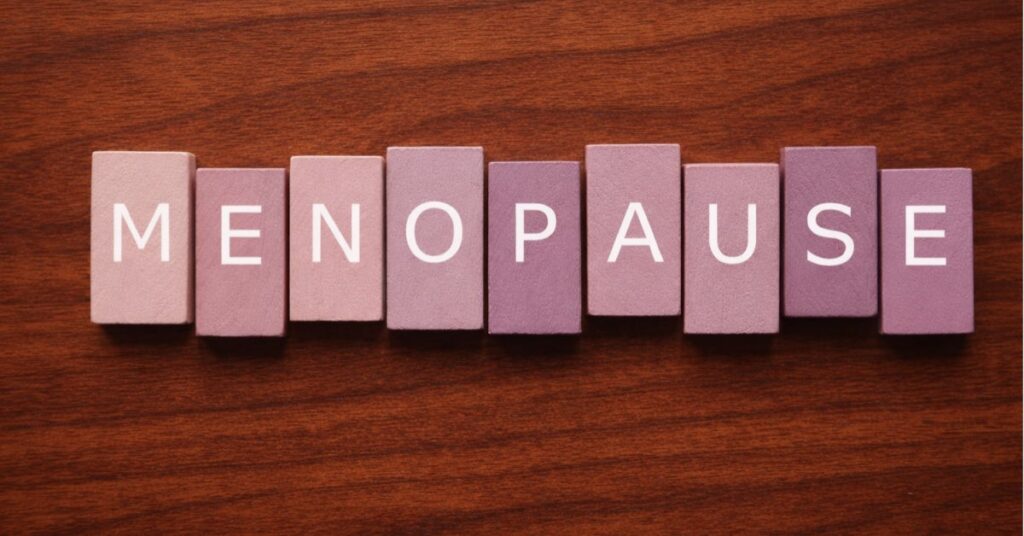 Menopause-spelled-out-in-mauve-tiles-on-cherry-wood