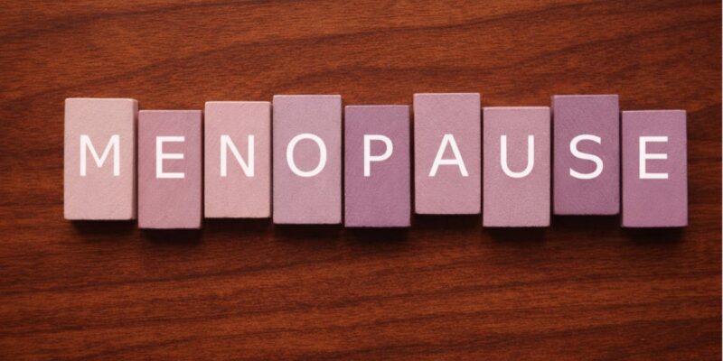 Menopause-spelled-out-in-mauve-tiles-on-cherry-wood